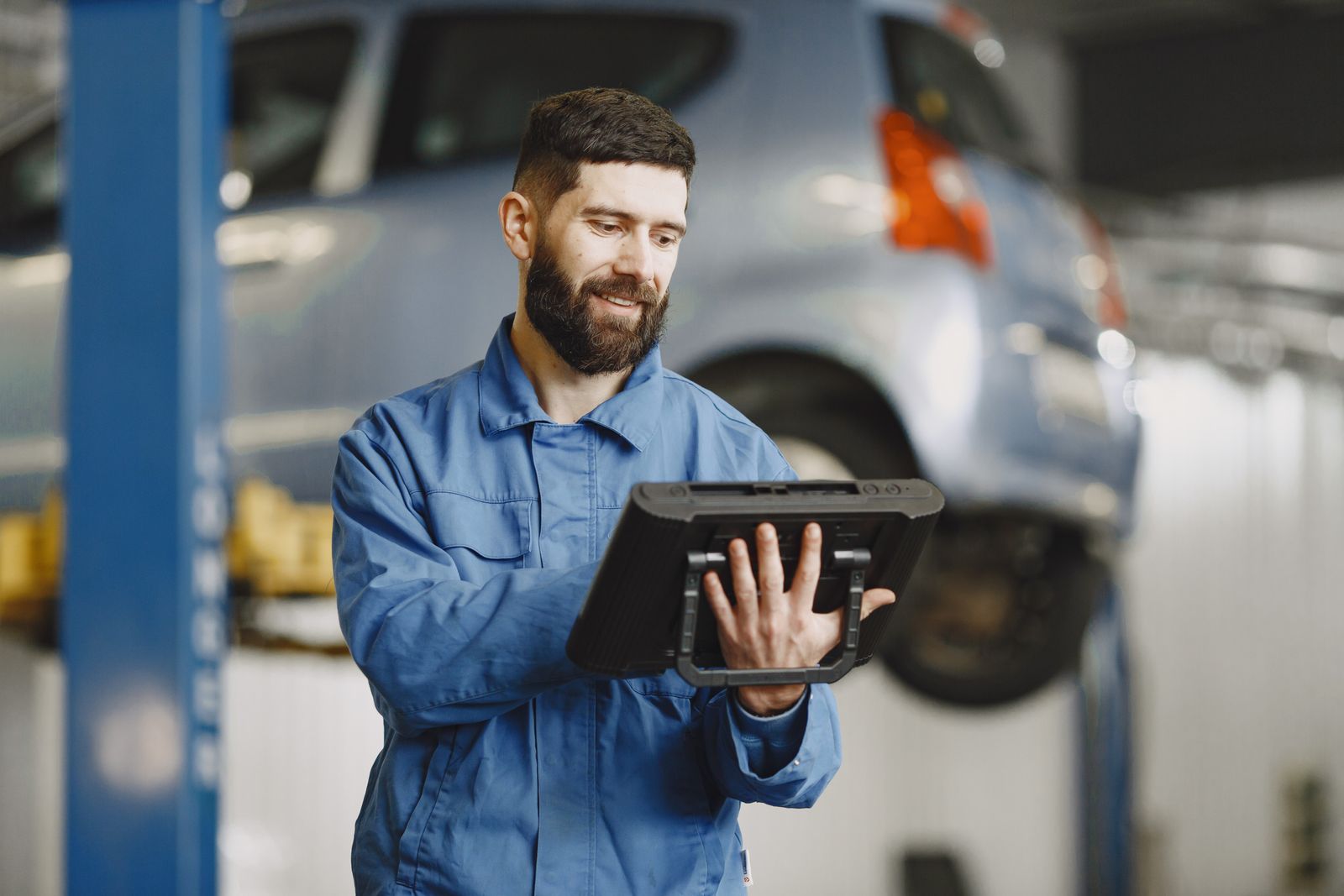 Vehicle technician using a digital tablet in a workshop